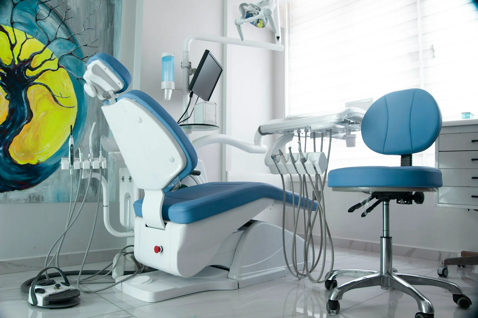 Treatment room with a dental chair and artwork on the wall
